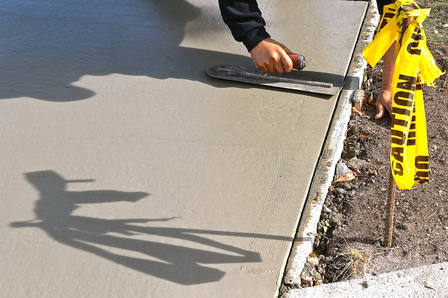 Concrete contractor smoothing a concrete driveway