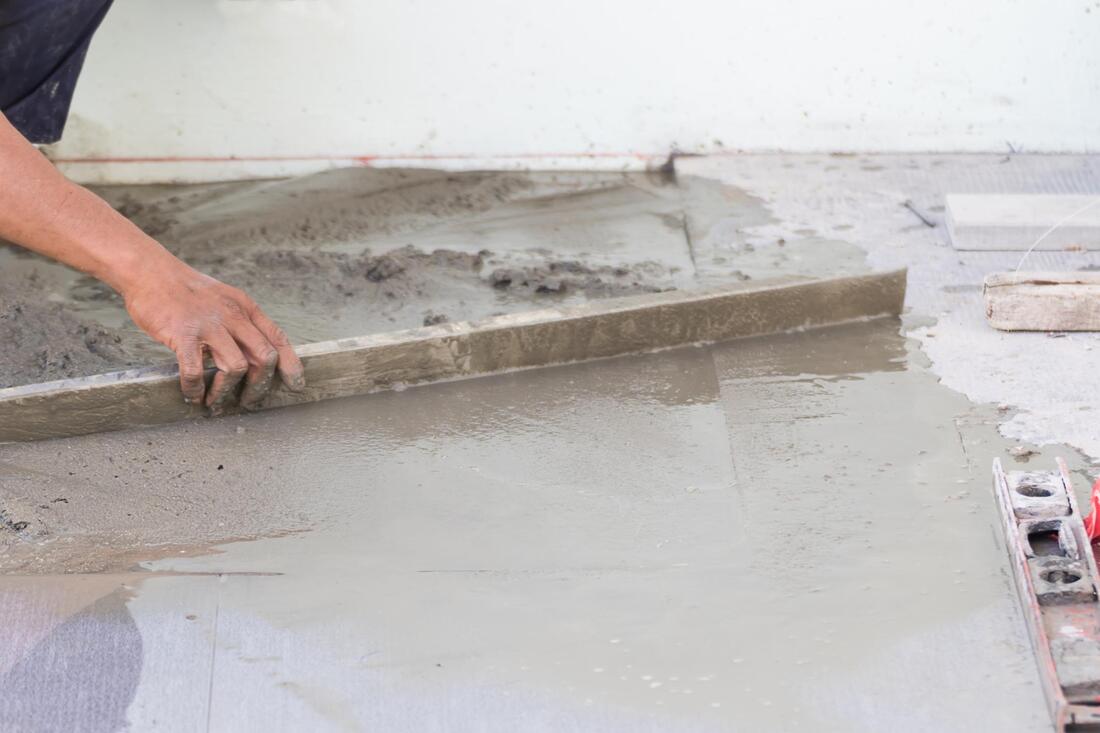 Workman repairing an area of concrete with fresh material